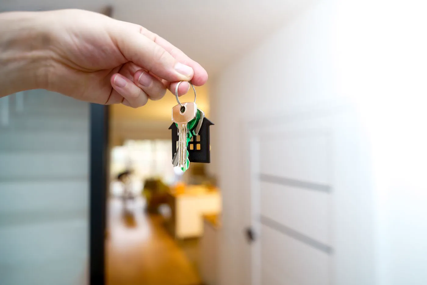 Hand holding up a bunch of keys in a bright home